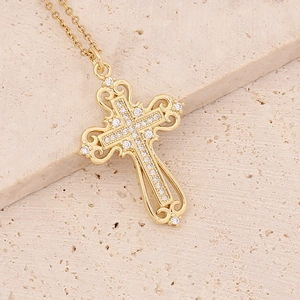 18K gold plated cross pendant necklace with micro-pave cubic zirconia on stone background