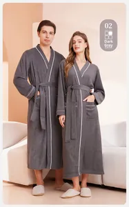 Detail of dark gray bathrobe featuring white piping on the collar and two front pockets
