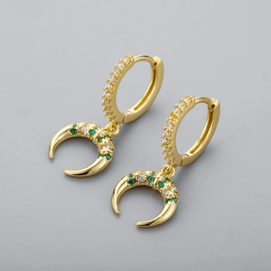 Détails de boucles d'oreilles en corne dorée avec des cristaux de zircone verts et blancs