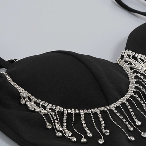 Close-up of black tank top featuring silver rhinestone fringe and sparkling crystal tassels