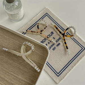 Three premium acetate claw clips with pearls in cream, light shell, and leopard pattern