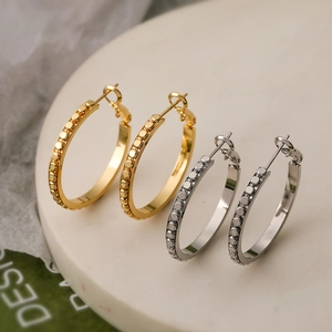 Orecchini a cerchio geometrici testurizzati color oro e argento su base minimalista