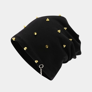 Detail of black knit beanie with gold cone studs and a silver metal ring accent