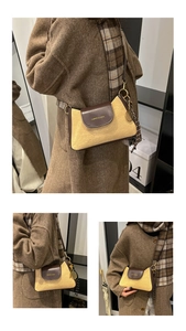 Detail of khaki textured crossbody bag with brown leather flap and tennis racket charm