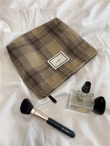 Detail of plaid wool cosmetic bag with metal zipper and Pleasant Time logo patch