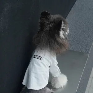 White pet dog shirt with handmade label shown from back on minimalist grey stairs