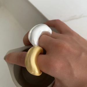 Gouden en zilveren geborstelde statement ringen met minimalistisch gebogen design
