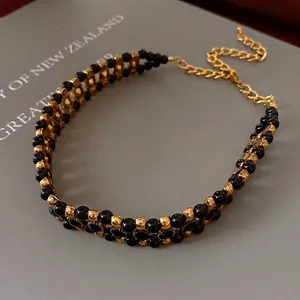 Vintage double-layer necklace with black beads, gold metal spacers, and adjustable chain