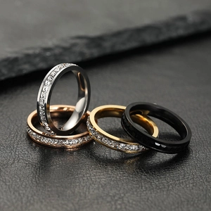 Macro shot of stainless steel eternity rings with square zircon stones on black leather