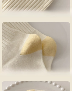 Detail of high-elastic ribbed cuffs and reinforced yellow heel on white cotton socks