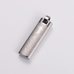 Macro shot of silver stainless steel pendant engraved with Lord's Prayer text and cross