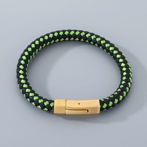 Detail of multi-layer black and green braided leather bracelet with gold metal clasp