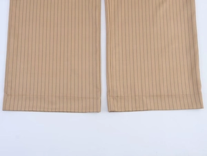 Detail of khaki striped linen blend trousers featuring fine stitching and twill texture