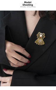Detailed view of an angel brooch with pearls and colorful rhinestones on a black suit lapel