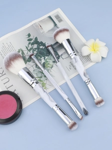 Detail of dual-ended marble makeup brushes with dual-tone bristles and pink blush set