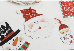 Detailed view of glittered wooden Christmas ornaments with Santa and Snowman motifs