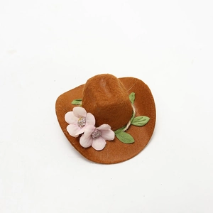 Close-up of mini brown felt cowboy hat with pink floral accents for bottle decor