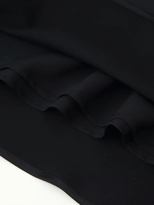 Detailed close-up of double-stitched hem on black satin fabric with smooth texture