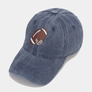 Detailed close-up of washed denim blue cap featuring leopard print heart and rugby embroidery