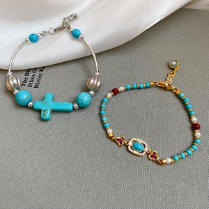 Close-up of bohemian beaded bracelets with turquoise, pearls, and evil eye charms