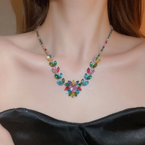 Close-up of a luxury silver necklace with colorful zircon leaves and a pink heart pendant