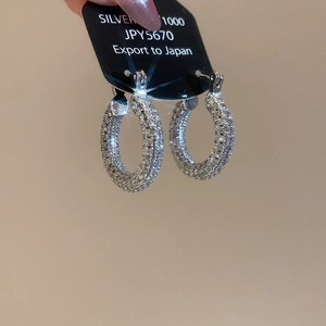 Close-up of U-shaped silver earrings with micro-paved cubic zirconia on display card