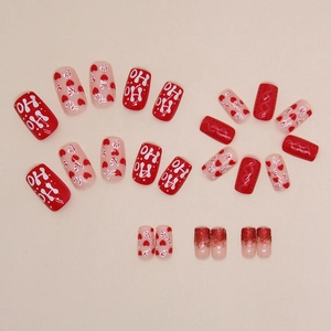 Christmas press-on nail set with red glitter hearts and Ho Ho Ho festive patterns