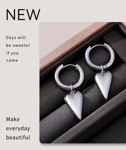 Detailed shot of polished silver heart pendants on hoop earrings inside a jewelry box