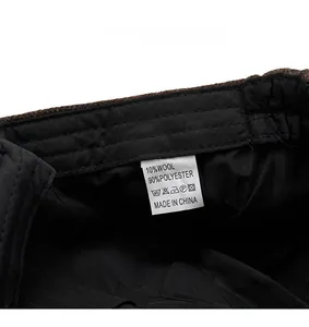 Detail view of newsboy hat care label showing 10% wool and 90% polyester fabric material