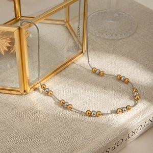 Detail of two-tone gold and silver beaded necklace on an elegant jewelry box