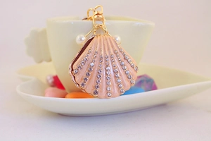 Close-up of golden shell keychain with sparkling crystals and elegant imitation pearls