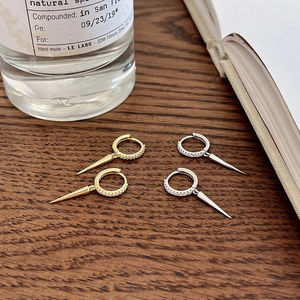 Macro view of gold and silver S925 sterling silver spike hoop earrings with pavé diamonds