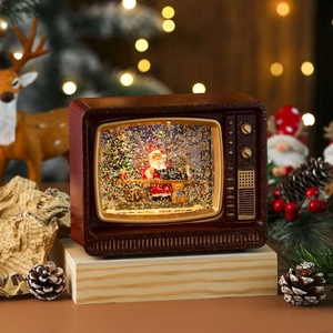 Close-up of retro TV music box with Santa Claus inside and warm bokeh background lights