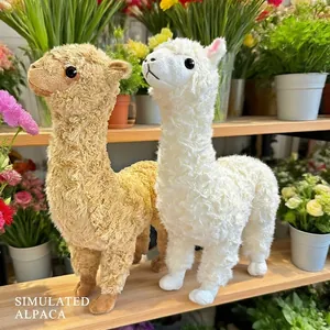 Cute white and brown alpaca plush toy dolls displayed on a shelf with garden flowers