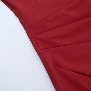 Close-up of dark red satin evening gown featuring elegant pleats and sparkling rhinestones