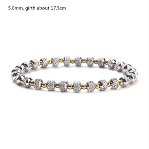 Detailed macro view of 5mm silver and gold beaded stretch bracelet with grid texture