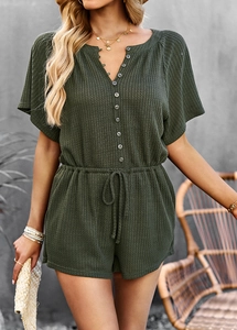 Close-up of green textured romper featuring short sleeves and drawstring waist details
