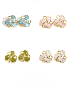Détail de boucles d'oreilles triangles géométriques en quatre couleurs d'émail et plaqué or
