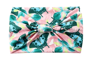 Detail of pink wide yoga headband featuring blue butterfly prints and a center knot