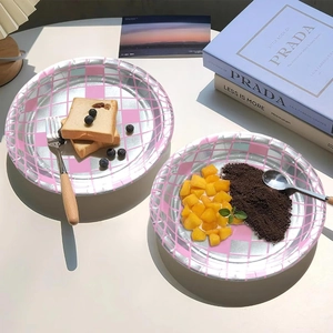 Pink and silver checkered disco party paper plates with food on a white table setting