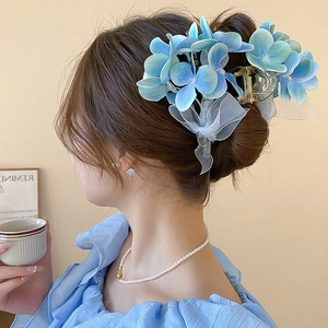 Nahaufnahme der hellblauen Organza-Blumen-Haarklammer mit Perlen-Details am Modell