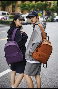Close-up of purple and caramel nylon backpacks shown by models in an urban setting