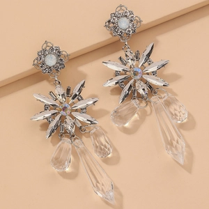 Macro detail of silver flower earrings with crystal tassels and sparkling teardrop pendants