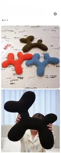 Close-up of soft teddy fleece dog-shaped pillows in brown, red, blue and black colors