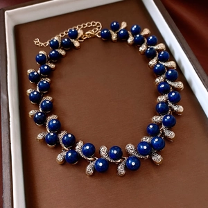 Close-up of golden bracelet with blue resin beads and crystals in a jewelry box
