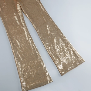 Detailed view of dense gold sequins on the sleeveless jumpsuit leg fabric