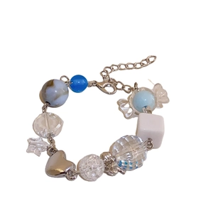 Blue marble beads and candy charm bracelet with silver heart pendant on white background