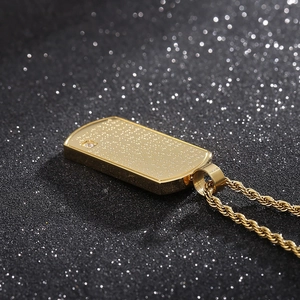 Détail du pendentif plaque dorée rectangulaire avec diamant et texte gravé sur chaîne