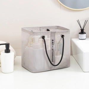 Grey mesh bath storage basket with black handles shown in a modern bathroom setting