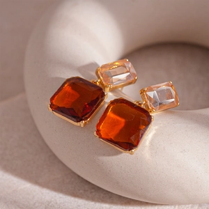 Gros plan sur des boucles d'oreilles vintage aux cristaux ambrés et champagne carrés
